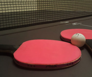 Pálky na stolní tenis na pingpongovém stole.